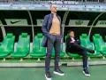 Trener Śląska Wrocław Ivan Djurdjevic stoi na tle zielonych siedzeń rezerwowych.