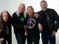 Czterech mężczyzn, TSA Dream Team, pozuje do zdjęcia. Dwóch z nich ma długie włosy, jeden w czarnej koszulce z zieloną gwiazdą, drugi w koszulce z symbolem pokoju.