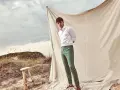 Un uomo con camicia bianca e pantalone verde, un look perfetto per l'estate. Scopri come abbinare un pantalone verde per un outfit fresco e alla moda.