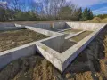 Fundament domu w budowie, pokazujący różne rodzaje betonu użyte do stworzenia solidnych fundamentów.