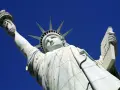 La Statue de la Liberté, une femme emblématique, lève sa torche vers le ciel. Elle porte une tablette, symbole de la loi.