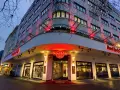 Das Hard Rock Cafe Berlin erstrahlt im Abendlicht. Rote Neonschilder und Beleuchtung werfen einen warmen Schein auf die Fassade des Gebäudes.