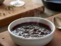 Un bol fumant de sauce marchand de vin, garnie d'herbes, prête à accompagner un plat savoureux.