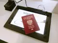 Polski paszport na ekranie tabletu w biurze paszportowym Włocławek. Obok skaner linii papilarnych.