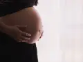 Gravid mage med händer som varsamt håller om den. Kanske funderar hon på proteinpulver gravid för att ge extra näring.