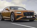 Pomarańczowy Bentley Continental GT na drodze. Sprawdź aktualną bentley cena i poczuj moc.