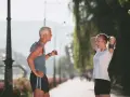 Coppia che discute a che ora andare a correre in un parco soleggiato.