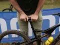 A rider adjusts their seat on a full-suspension bike, ready for an enduro mountain biking adventure.