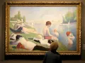 Un peintre pointilliste a capturé une scène estivale au bord de l'eau, avec des baigneurs et des voiliers.