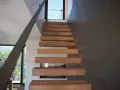 Moderna scala interna con gradini in legno sospesi, un'idea di design minimalista e funzionale.