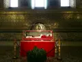 Relikwie papieża, najdłużej panującego, w szklanej trumnie. Złote mozaiki i marmury zdobią wnętrze.