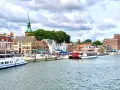 Hafen von Kappeln mit Schiffen und historischen Gebäuden. Entdecken Sie die Kappeln Geheimtipps für Ihren nächsten Urlaub.