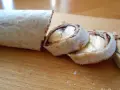 Słodka tortilla z bananem i czekoladą, pokrojona w rolki, wygląda jak pyszny deser.
