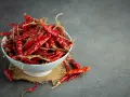Miseczka pełna suszonych papryczek chili, których ostrość pochodzi od kapsaicyny. Co to jest kapsaicyna? To związek chemiczny odpowiedzialny za pieczenie.