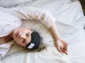 Donna con mascherina per dormire, cerca rimedi per l'insonnia da stress.