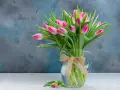 Bukiet różowych tulipanów w dzbanku z jutową kokardą. Czy wiesz, że tulipan to symbol wiosny i miłości?