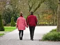 Para idealna na pierwszą randkę, na której złapać za rękę. Spacerują alejką w parku, trzymając się za ręce.