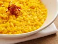 Miseczka kremowego risotto alla Milanese, ozdobiona nitkami szafranu.