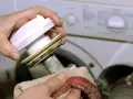 Hände reinigen das Flusensieb einer Bosch Waschmaschine. Regelmäßige Pflege sorgt für einwandfreie Funktion.