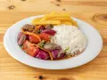 Lomo saltado con arroz blanco, papas fritas, carne, cebolla roja y tomate. Un plato peruano delicioso.