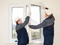 Installatori montano una finestra, mostrando le spallette finestre cosa sono e come si integrano nel muro.