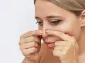 Kvinna undersöker sin näsa, kanske för pormask behandling.