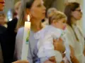 Chrzest dziecka. Czy świadek chrztu musi mieć zaświadczenie? Płonąca świeca chrzcielna w dłoniach.