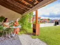 Due donne brindano su un terrazzo con prato. Sullo sfondo, una pompa di calore sul tetto.
