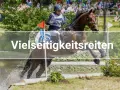 Ein Reiter und sein Pferd überwinden einen Wassergraben bei einem Vielseitigkeitsreiten-Wettbewerb.