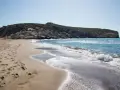 Piękne turcja plaże z piaszczystym brzegiem i skalistym wzgórzem w tle. Fale delikatnie rozbijają się o brzeg.