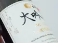 Butelka sake z napisem "DAI GIN". Na etykiecie widać skalę smaku i temperatury podania.