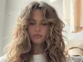 Chica con pelo rizado y flequillo desfilado, inspirador para tipos de flequillo para pelo rizado.