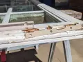 Damaged wood window frame, showing rot and peeling paint, indicating a need for wood window repair.
