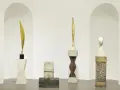 Rzeźby inspirowane twórczością **Constantin Brâncuși**: złoty liść, kamienna postać, drewniany rdzeń i biała głowa.