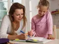 Mama i córka uczą się razem, wspierając edukację domową.