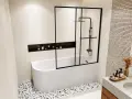 Salle de bain moderne avec baignoire blanche, paroi de douche noire et étagère murale. La taille baignoire semble parfaite pour un moment de détente.