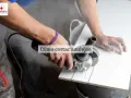 Man con amoladora cortando porcelánico, creando líneas de corte con lápiz azul.