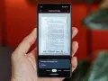 Telefon skanuje dokument, pokazując, jak zeskanować zdjęcie telefonem. Widoczny jest interfejs aplikacji Obiektyw Google.