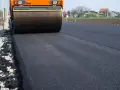 Walec drogowy ugniata świeży asfalt. Zastanawiasz się, ile kosztuje 100 m asfaltu na drodze dojazdowej do domu?