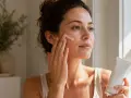 Kobieta aplikuje krem na twarz, zastanawiając się, retinol co to jest i jak działa na skórę.