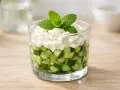 Verrine fraîcheur : dés de concombre croquants surmontés d'une crème onctueuse et d'une touche de menthe. Un délice léger et rafraîchissant.