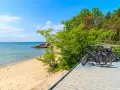 Rowerzyści odpoczywają na plaży, a ich rowery czekają na dalszą podróż po malowniczych pomorskich trasach rowerowych.