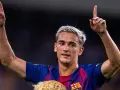 Pablo Gavi, con el pelo teñido de rubio, levanta los brazos y señala al cielo, celebrando un gol.