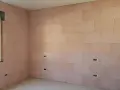 Pannelli rosa per cappotto interno con lana di roccia e cartongesso, con predisposizioni per prese elettriche e una finestra.