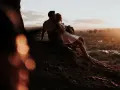 Para uczci 5 rocznicę ślubu, siedząc na wzgórzu o zachodzie słońca, otuleni ciepłym blaskiem.