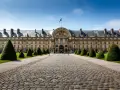 El majestuoso edificio de Les Invalides, donde se encuentra la tumba de Napoleón, con su fachada dorada y jardines cuidados.
