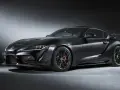 Matowa czerń podkreśla agresywną sylwetkę sportowego coupe Toyota GR Supra. Widoczne czerwone zaciski hamulcowe i aerodynamiczne dodatki.