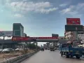 Driving in Lebanon, a busy street with cars, trucks, and billboards advertising various services and products.