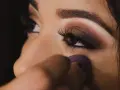 Un œil maquillé avec un smoky eyes facile, rehaussé de paillettes. Une éponge violette est utilisée pour estomper le fond de teint.