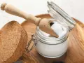 Ein Glas mit weißem Pulver, das nach "was ist Soda" fragt, daneben ein Holzschaufelchen und ein Korken.